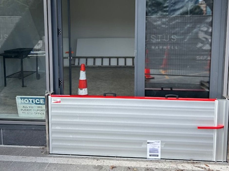 Flood barrier installed at a glass doorway to help protect a building entrance from floodwater